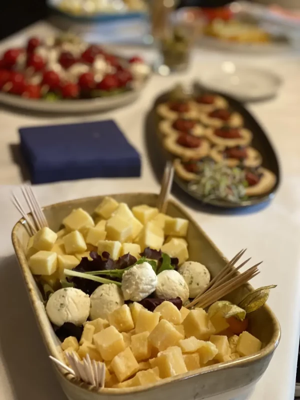 Käseplatte mit würzigem und mildem Käse in Würfeln, garniert mit Kräuter-Frischkäsebällchen.