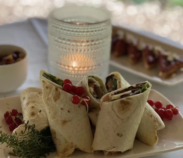 Wraps mit Gemüsefüllung, garniert mit frischen roten Johannisbeeren und Kräutern.