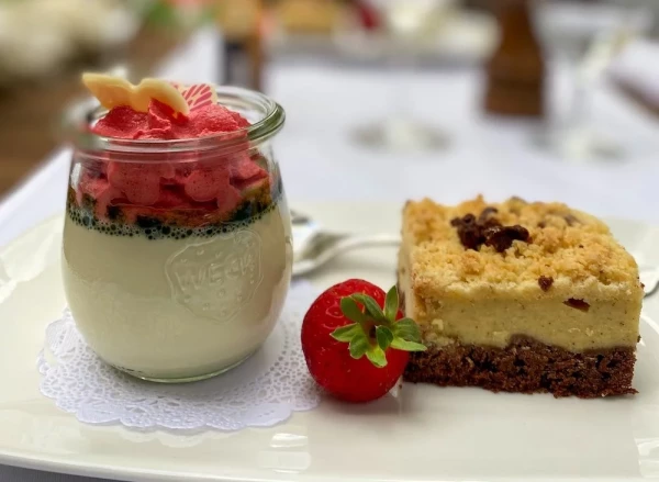 Dessert-Duo: Erfrischendes Himbeersorbet auf Vanillemousse im Weckglas und Streuselkuchen, garniert mit frischer Erdbeere.