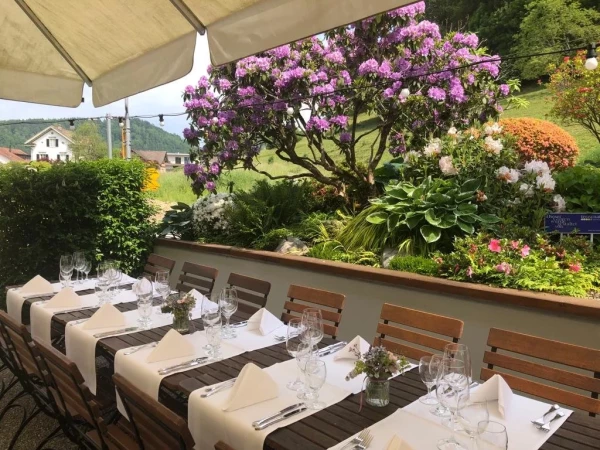 Gediegenes Ambiente im Biergarten mit Blick auf die grüne Landschaft.