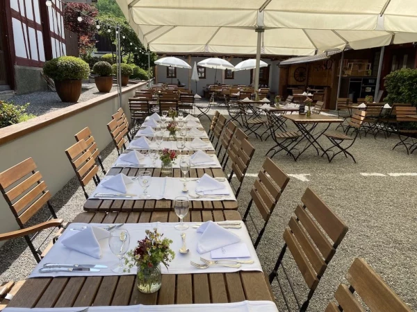 Elegantes Tischgedeck unter weissen Sonnenschirmen, ideal für Familienfeiern.